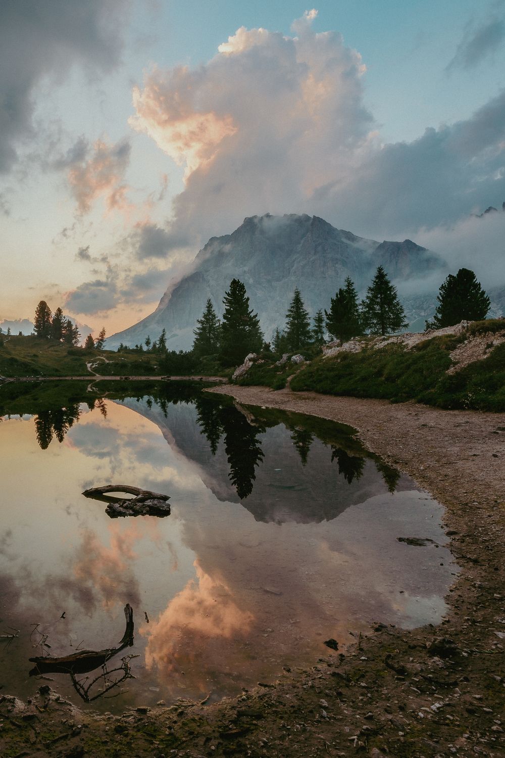 Traveller looking at a mountain lake at sunrise